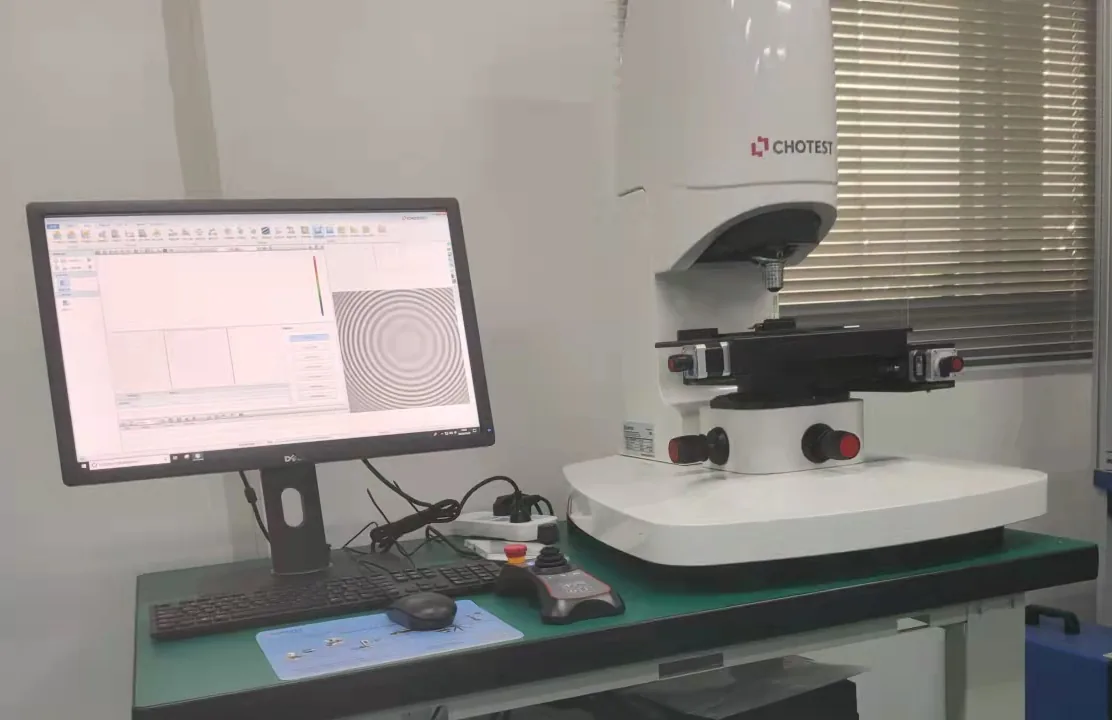 Weißlichtinterferometer auf einem Labortisch, Monitor zeigt ringförmige Interferenzstreifen